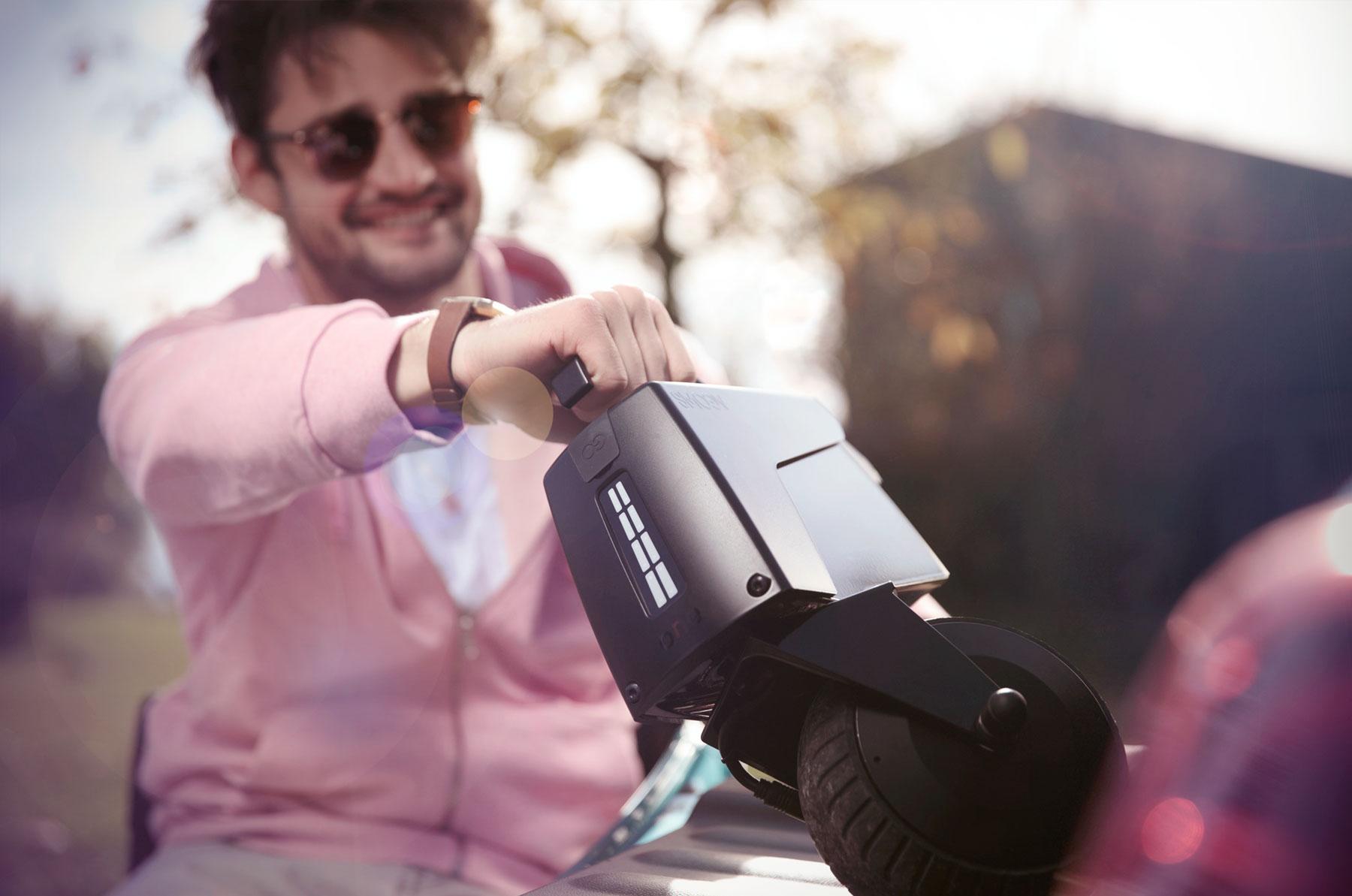 Junger Mann dockt smoov Elektroantrieb mit einer Hand vom Rollstuhl ab.