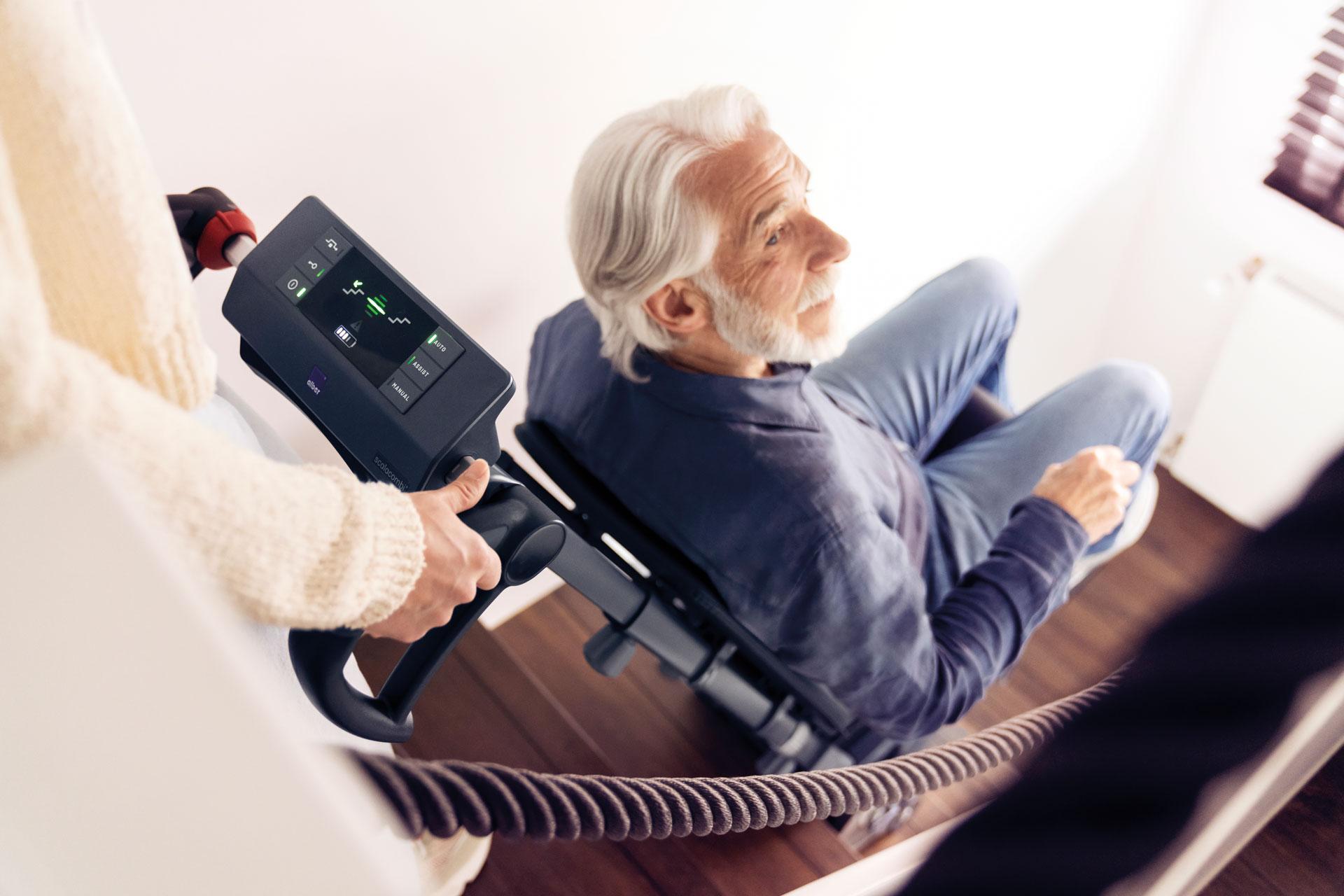 Frau mit Händen an ErgoBalance-Griffen mit Blick aufs Display beim scalamobil/scalacombi Steigvorgang