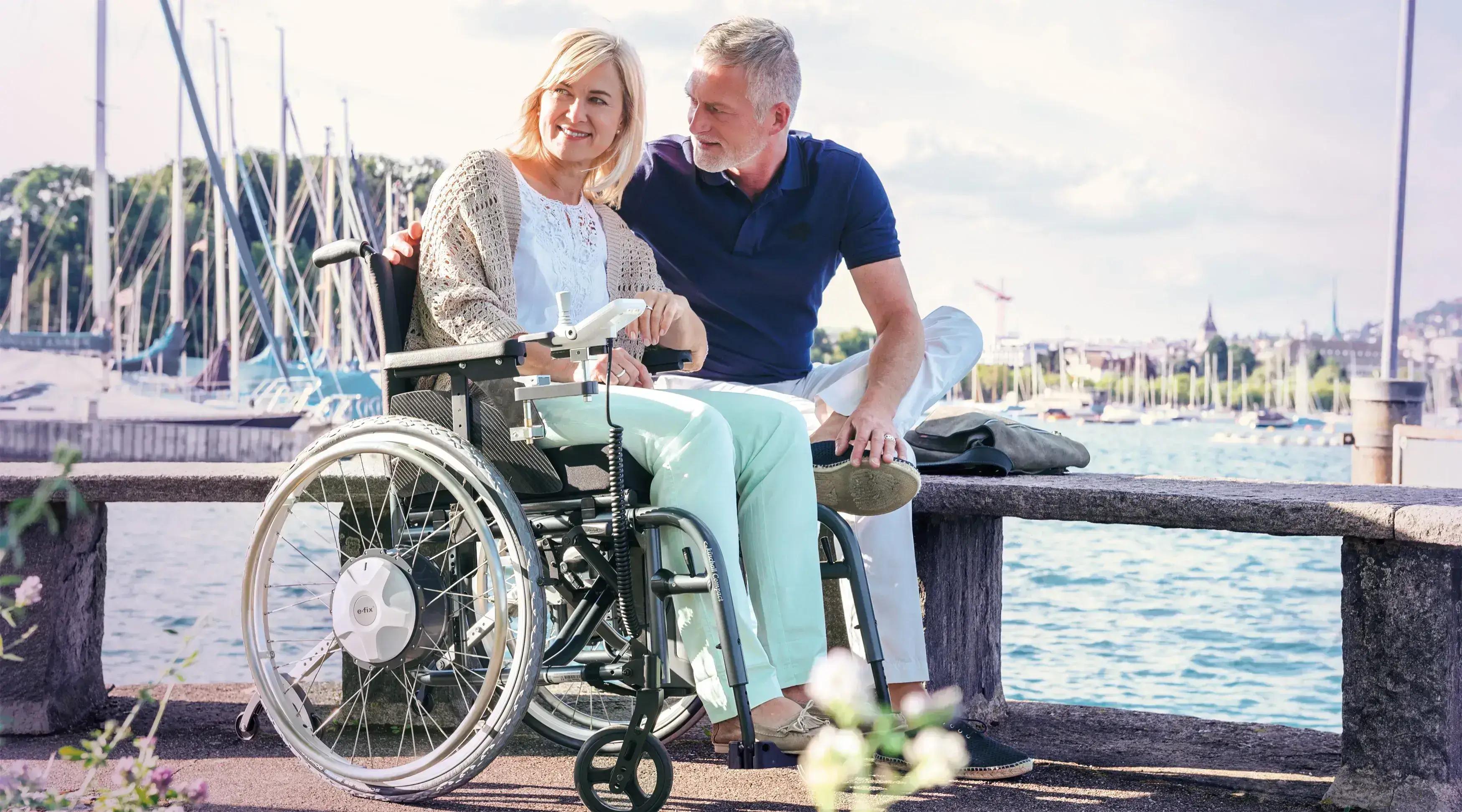 Frau sitzt im Rollstuhl mit Elektroantrieb e-fix neben ihrem Mann