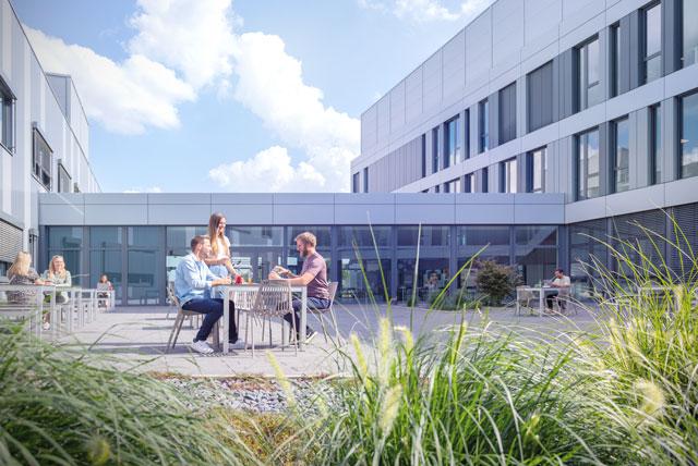 Die Mitarbeitenden der Alber GmbH genießen ihre Mittagspause im begrünten Innenhof des Firmengebäudes