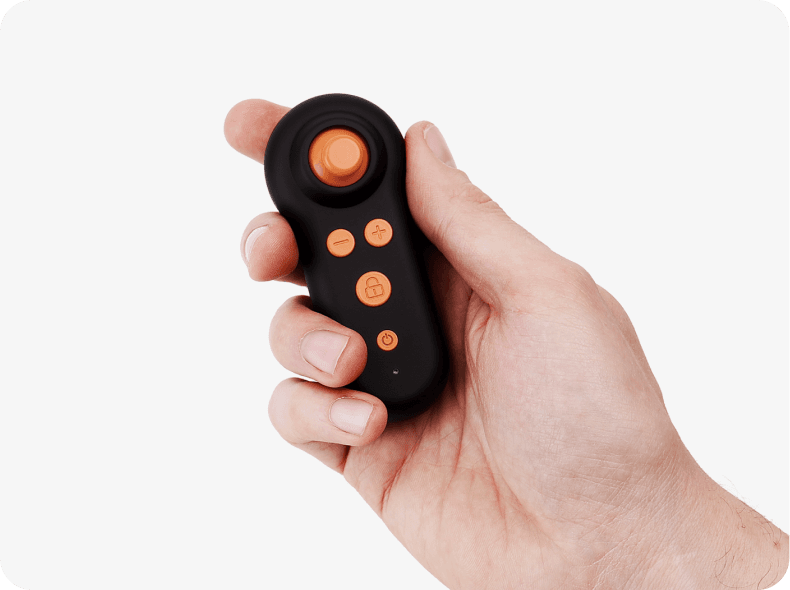 Ansicht der schwarzen kleinen Fernbedienung mit orangen Bedienelementen für erivo carbon in einer gepflegten Männerhand.