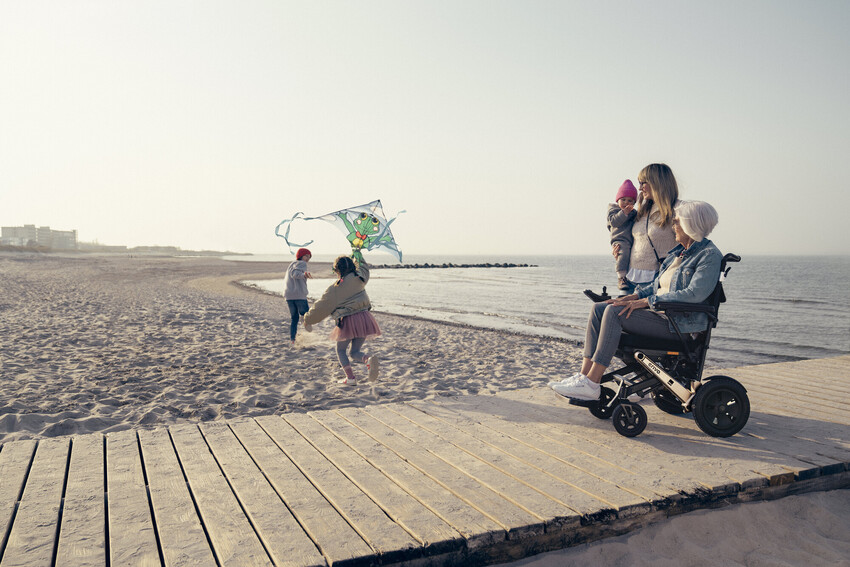 Familie macht Urlaub mit Rollstuhl am Meer